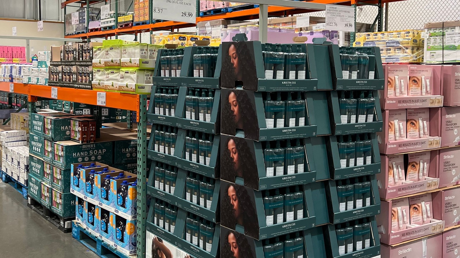 A warehouse-store aisle with pallets of stacked product and tall racking above