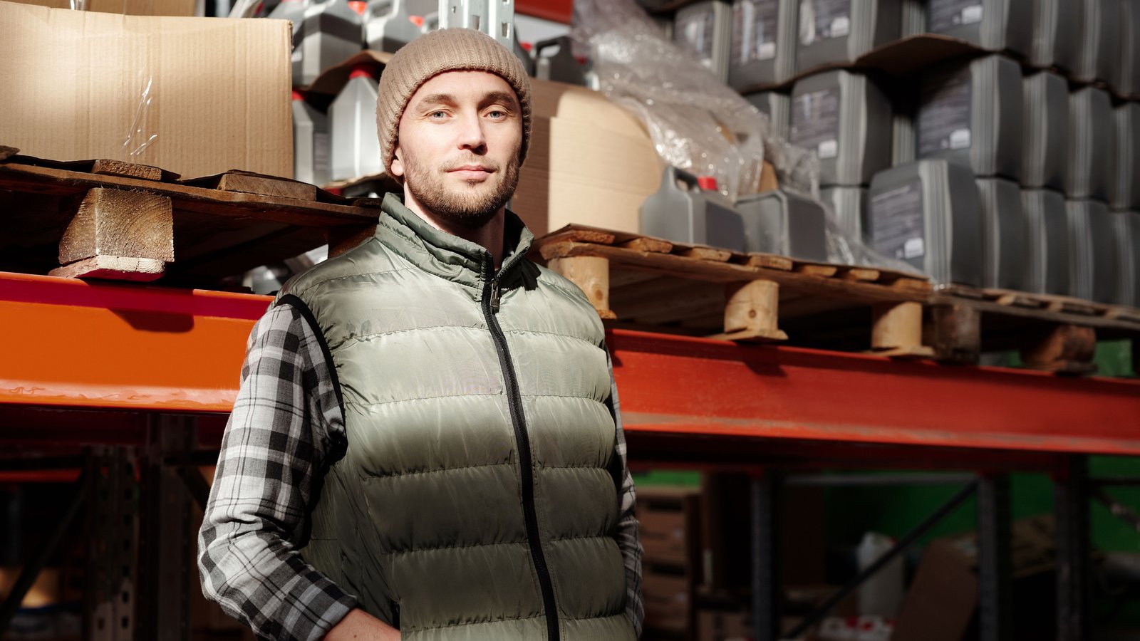 A warehouse worker standing in front of pallet racking stacked with goods