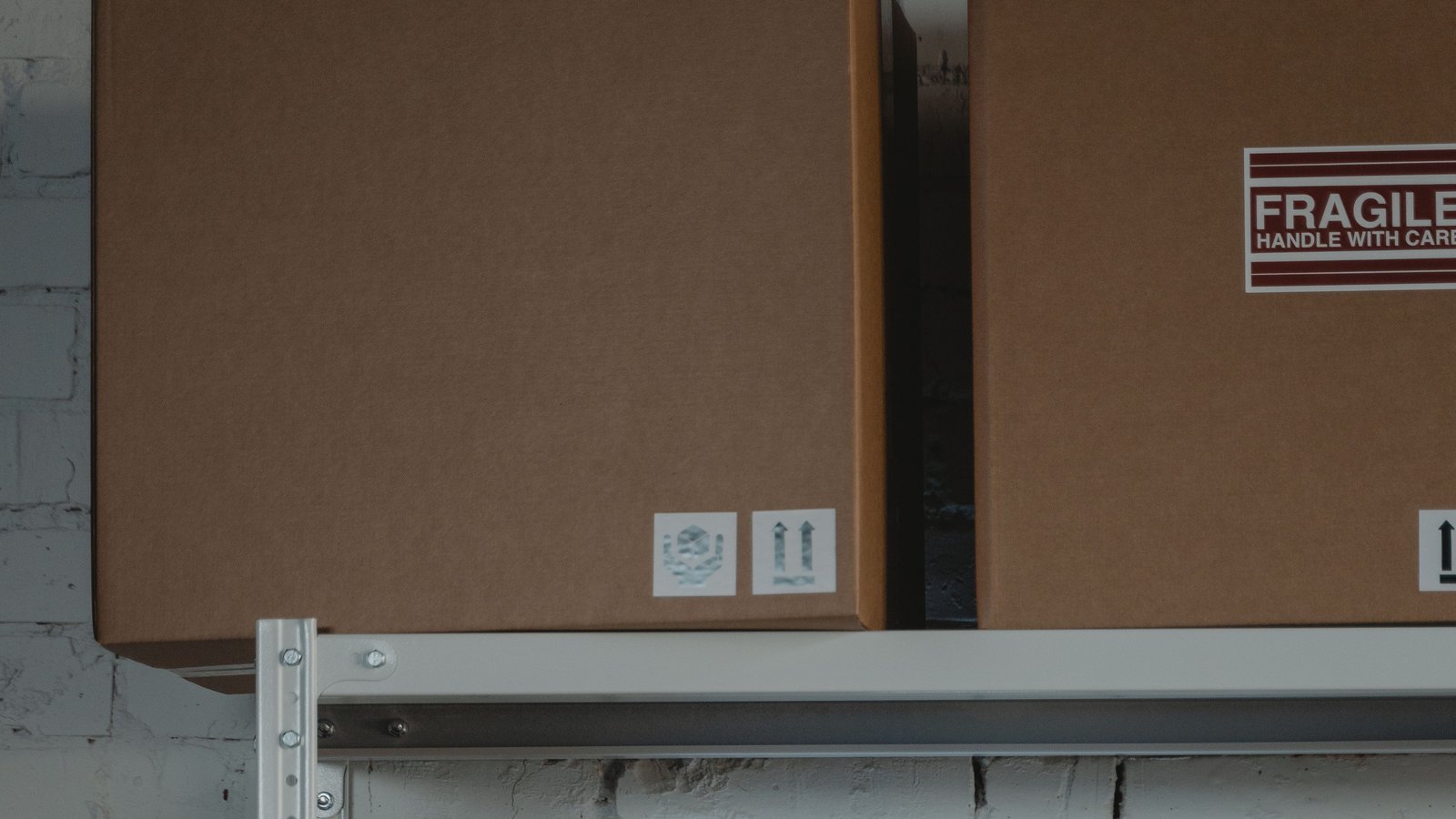 Shelving holding flat mailer boxes, padded envelopes and fragile-marked cartons